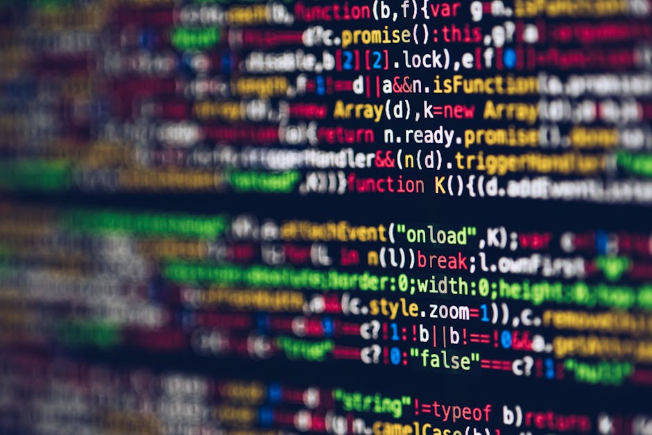 A close-up view of a computer screen displaying multicolored lines of programming code with various keywords, functions, and syntax highlighted in bright green, red, blue, yellow, and white. The code 